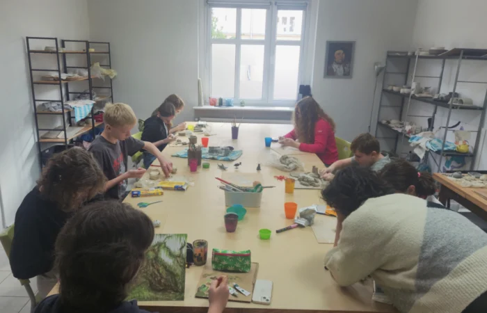 Młodzież na zajęciach ceramiki lepi naczynia w glinie