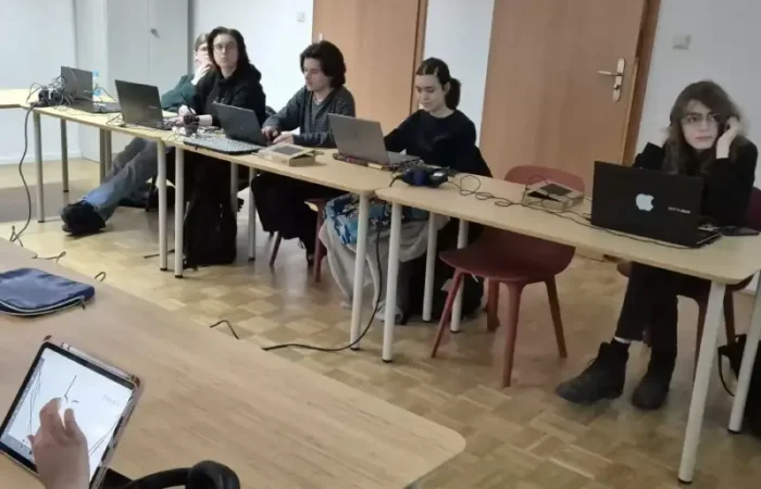 Strudenci grafiki pracują przy komputerach w pracowni